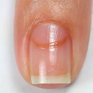 El segundo paso para hacerte unas uñas media luna es marcar la zona de la cutícula con el esmalte de essie que quieras usar.  