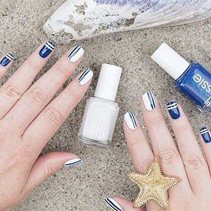 Combina el esmalte Blanc de essie con uno azul y conseguirás unas uñas decoradas con rayas de estilo marinero.