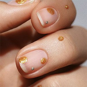 Usa los esmaltes metalizados de essie para crear una manicura con puntos desiguales de estilo minimalista en tus uñas cortas.