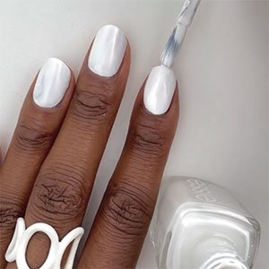 Para el primer paso de una manicura tie-dye no pueden faltar una capa de base y otra del esmalte de fondo que vayas a utilizar. En este caso, el cuidado Here to stay y el tono Blanc, ambos de essie, serán tus aliados.