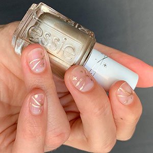 Aplica una capa de cualquier top coat de essie para que tu diseño de uñas con estrellas minimalista dure más tiempo. 