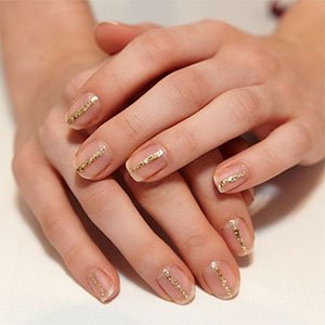 Si buscas una manicura navideña minimalista, traza una línea con un esmalte metalizado como Penny Talk de essie.