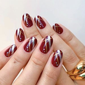 El color borgoña es un incondicional de las uñas de Navidad y lo sabes. Atrévete con este diseño protagonizado por el esmalte Maki me happy de essie y los tonos plateado y dorado, Gadget Free y Penny Talk, respectivamente.