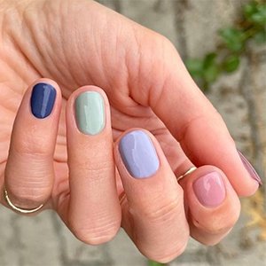 Las uñas azul oscuro también pueden llevarse a la manicura skittle. Aquí el tono zafiro oscuro Bobbing for baubles es la nota de peso de una manicura pastel superacertada.