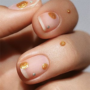 Utiliza el endurecedor de uñas Hard to resist como fondo y el esmalte Mani Thanks de essie para ir dibujando los lunares. ¡Las uñas doradas también tienen su lado puntillista!