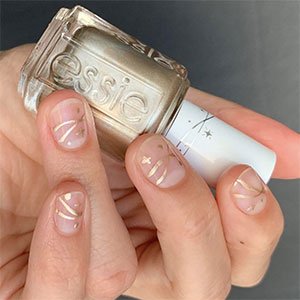Con el endurecedor Hard to resist y el esmalte Mani Thanks puedes marcarte unas uñas doradas formato minimalista de impresión. 