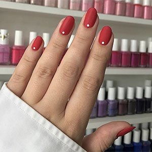 Dos capas de cualquiera de los muchísimos tonos rojos de essie y un puntito del esmalte Blanc y ya tienes un diseño de uñas sencillo y de lo más resultón. 