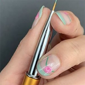 Si apuestas por unas uñas con flores, la elección de si las quieres llevar con tallo o no, solo depende de ti. Si eliges que sí, dibújalos con un cepillo superfinito y preciso y elige un tono de essie que cree contraste.