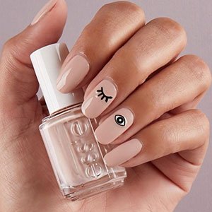 Combina un pintauñas nude de essie con este diseño de uñas con ojos para un resultado minimalista.  