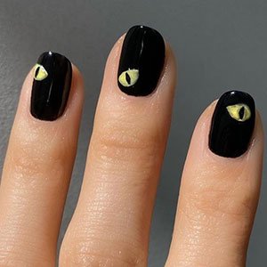 ¿Buscas un diseño de uñas con ojos para Halloween? Recrea este con el esmalte Licorice de essie y un dibujo felino.    