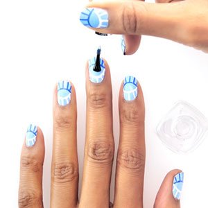 Termina tu diseño de uñas con ojos aplicando una capa del top coat Good to go de essie. 
