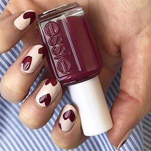 Unas uñas burdeos con corazones sí que es sumarse al carro de la tendencia por todo lo alto. Replica las de la imagen con el esmalte nude Sand Tropez de essie y el ciruela Sole Mate.
