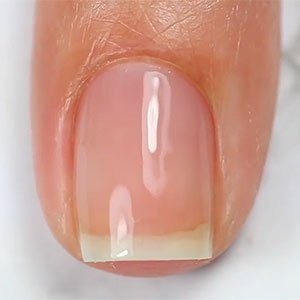 El primer paso para hacerte unas uñas media luna es aplicar una base protectora como Strong Start de essie.  