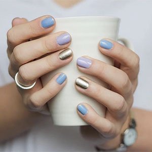 ¿Qué te parecen unas uñas multicolor con toque glitter? Consíguelas añadiendo la nota brillante gracias al tono dorado Penny Talk de essie.